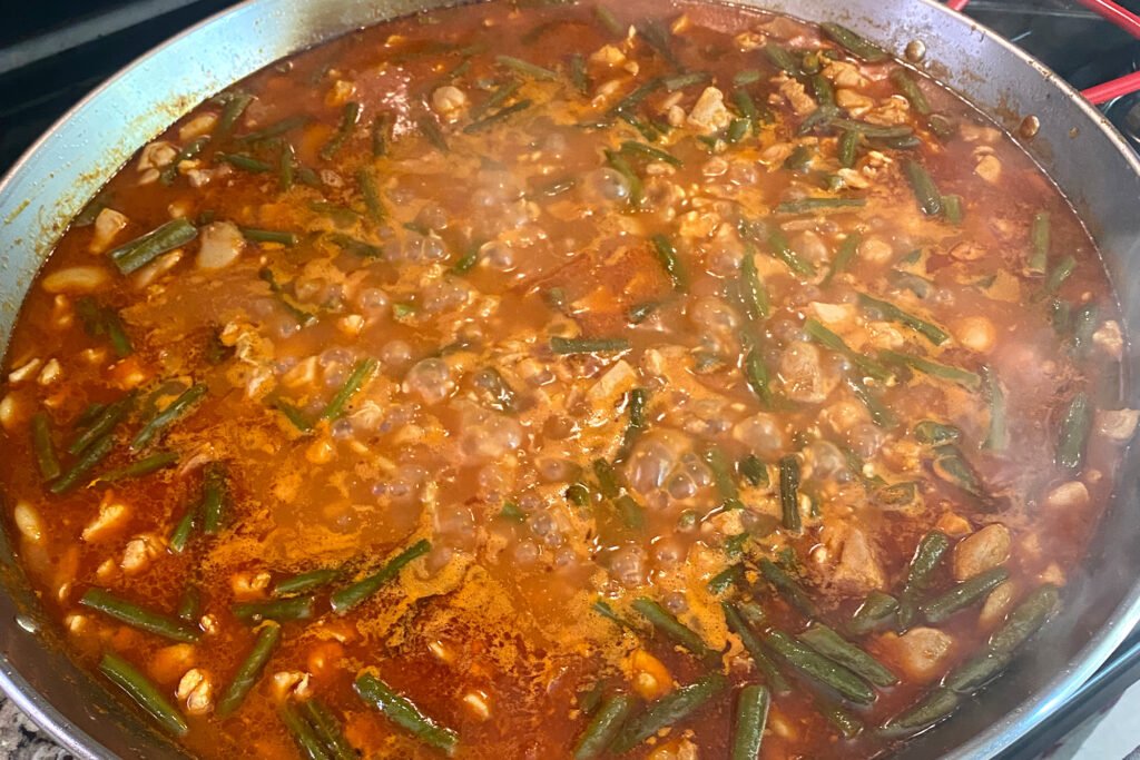 spanish paella simmering in a paella pan